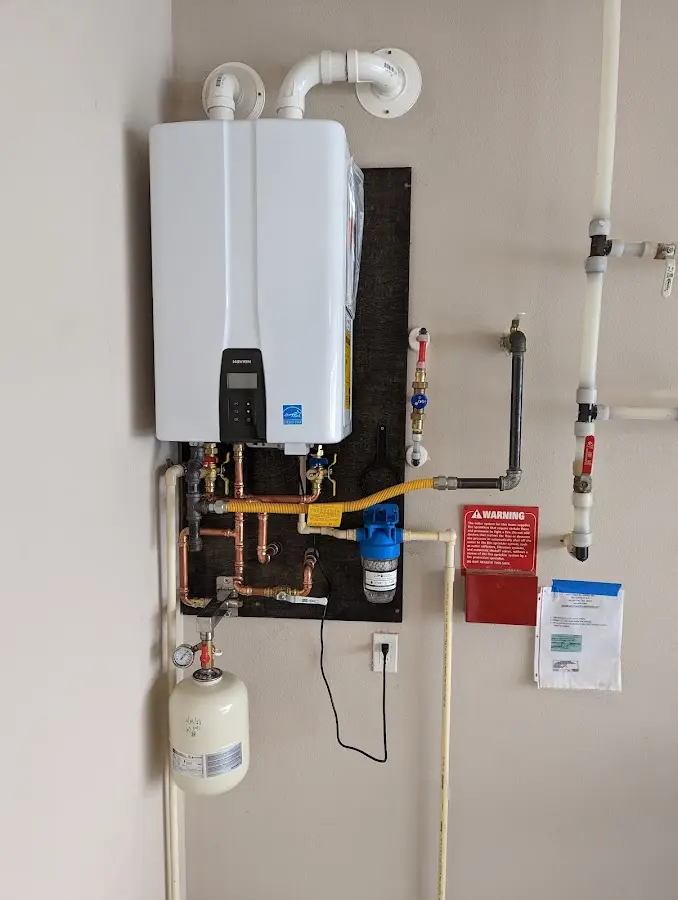 Professional plumber installing copper piping in a Penfield home